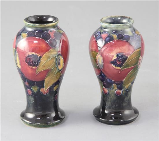 Two Moorcroft miniature pomegranate pattern baluster vases, height 10cm